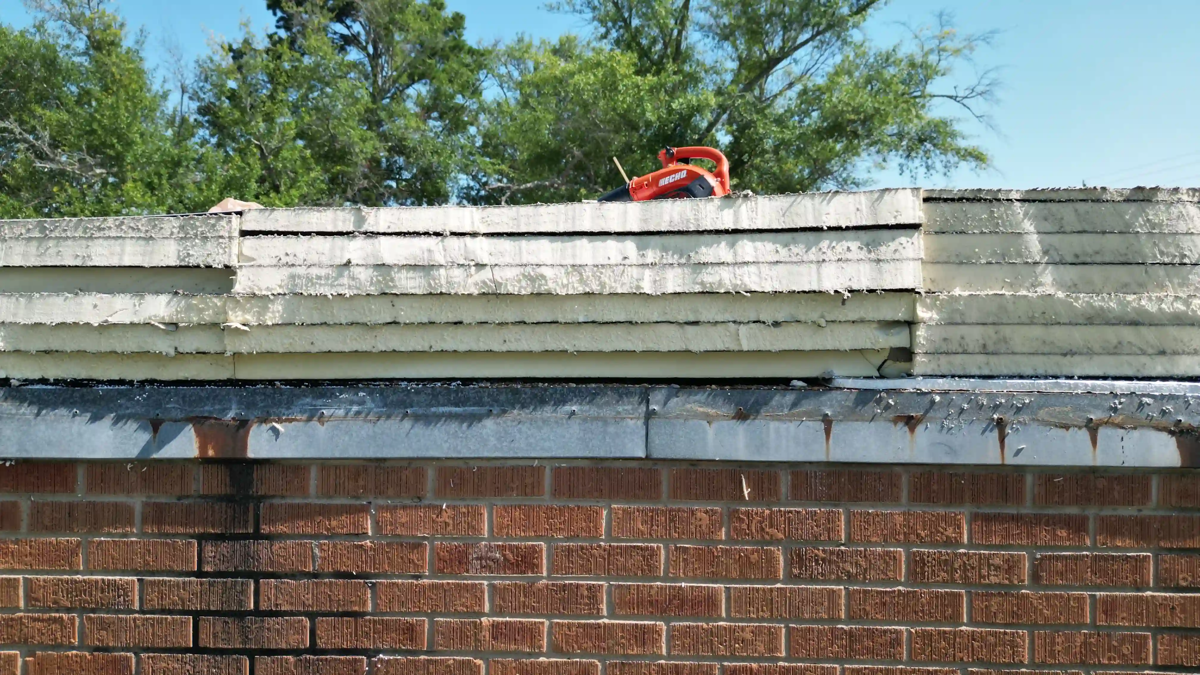 Commercial building mid-reroof with the old roof layers stripped back to fresh decking
