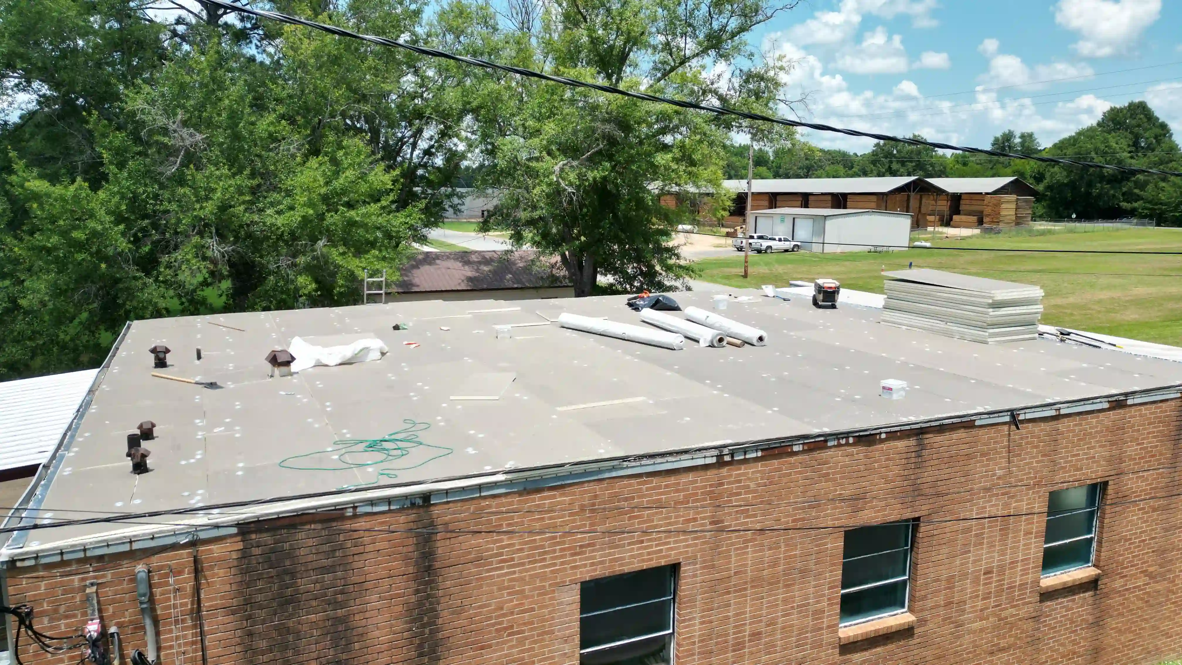 Crew working on a flat commercial roof membrane installation