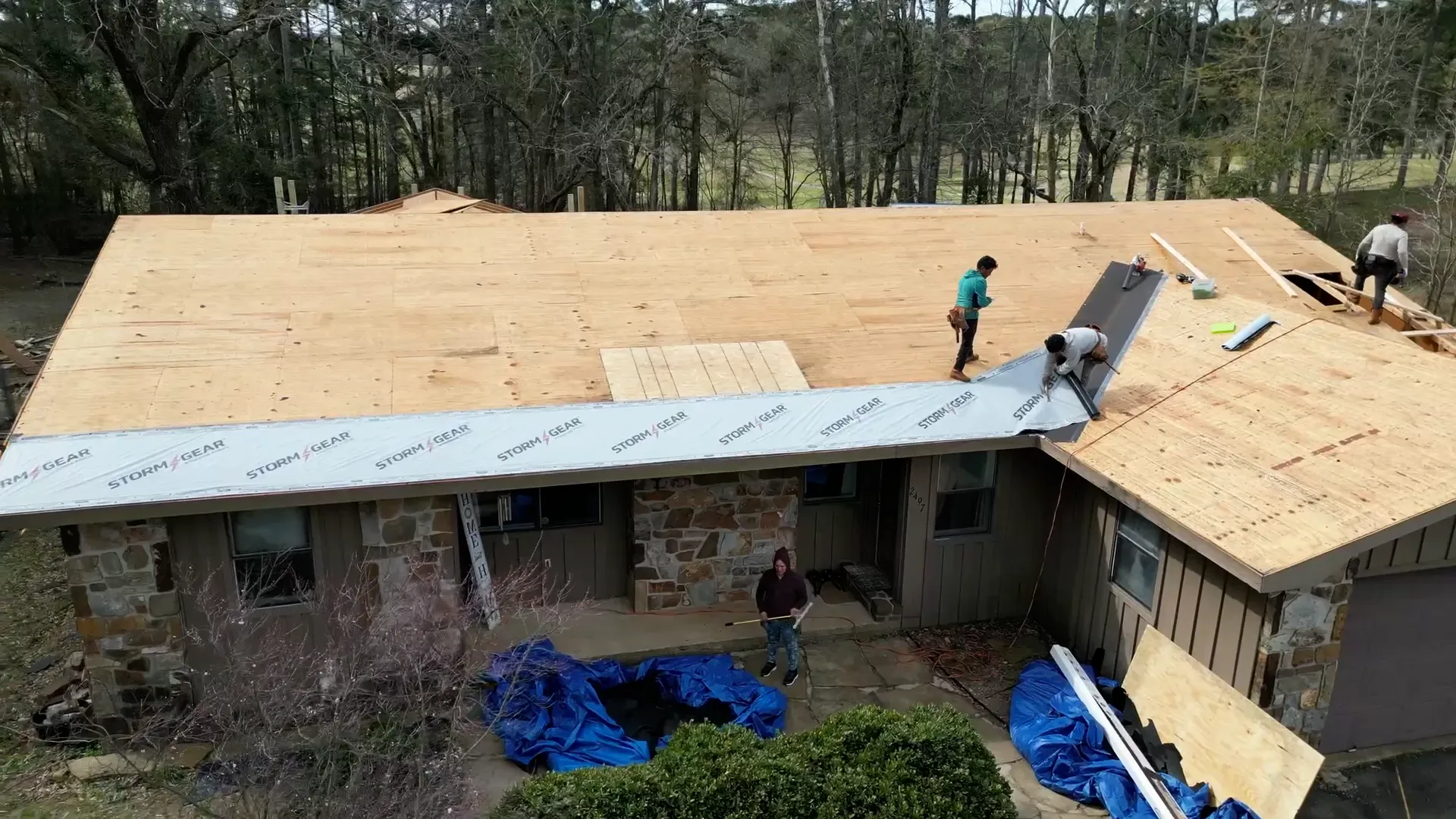 Fresh plywood decking and synthetic underlayment going down on a new roof install